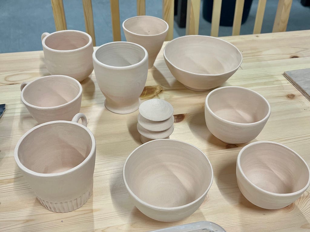 Ten bisqueware on a wooden table.