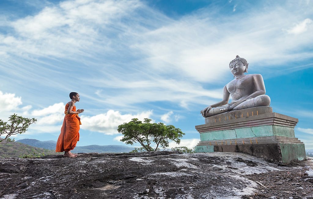 Gautam Buddha and Buddhism man. In this image A Buddhism Man is Seen the Gautam buddha in the infront of Gautam buddha.