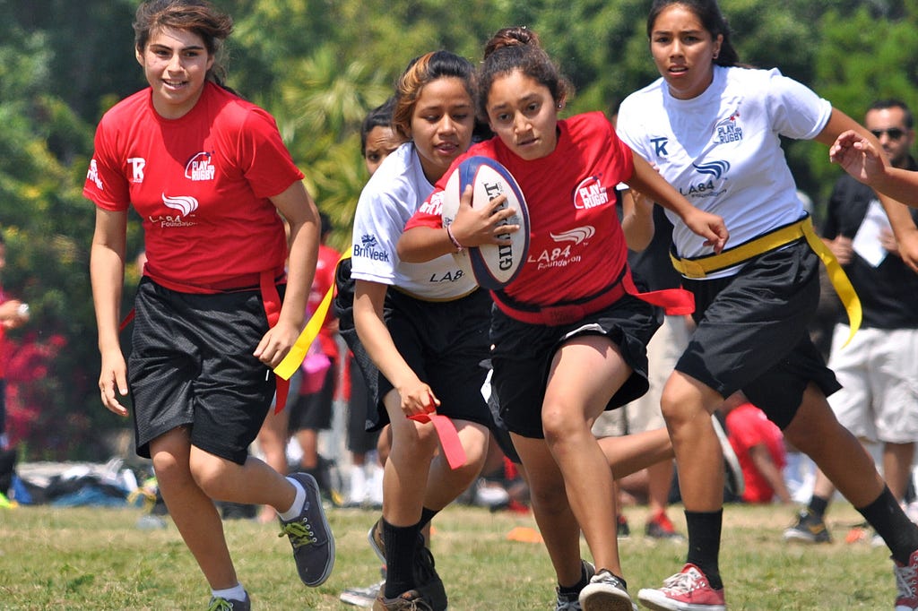 Girls playing rugby.