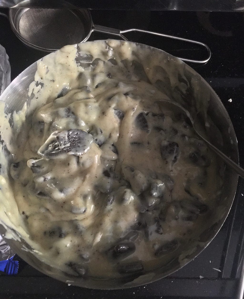 Heated Mixture of Milky Bar and Condensed Milk added to Crushed Oreo Cookies