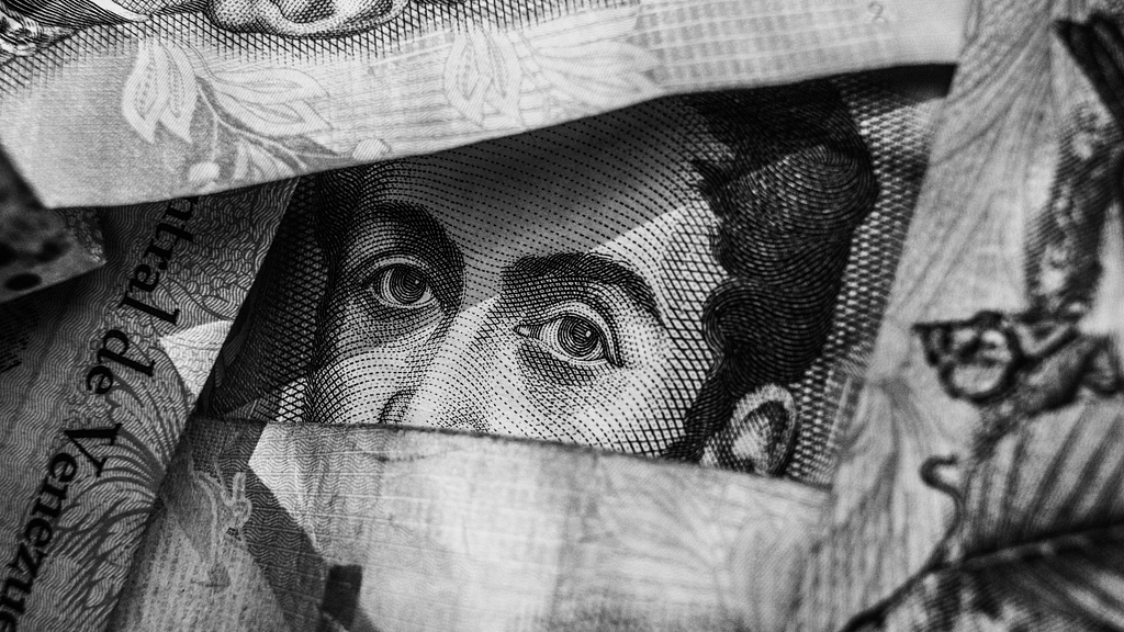 Close-up of a banknote photo, showing a texture-rich detail of a printed face.