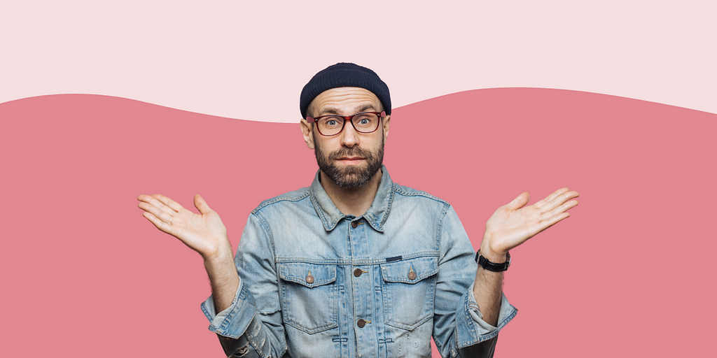 Confused man shrugging against a pink background