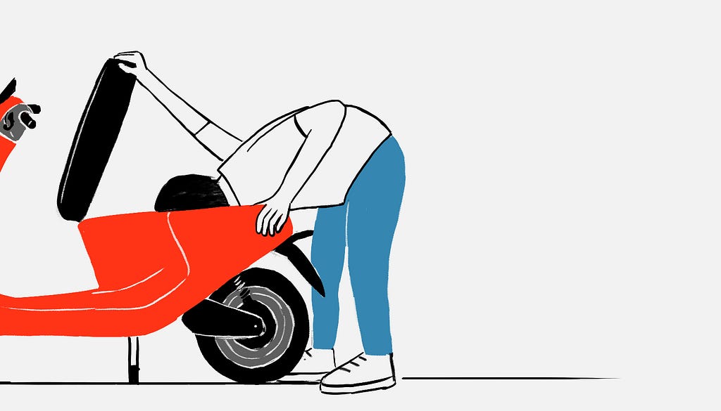 A person looking beneath a scooter’s saddle.