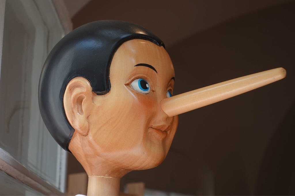 The head of a wooden Pinocchio doll with a long nose.