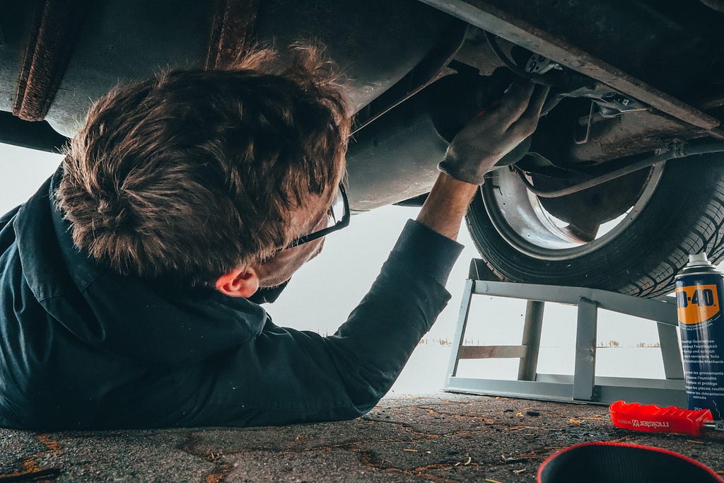 A man working on a car under the hood