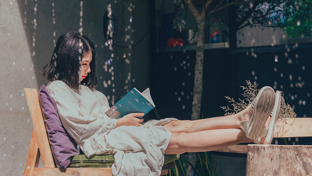 Girl wearing purple jacket reading book