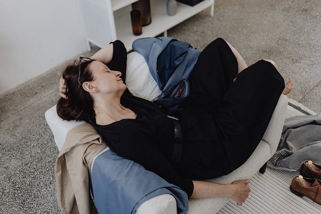 Older woman asleep curled up in a chair