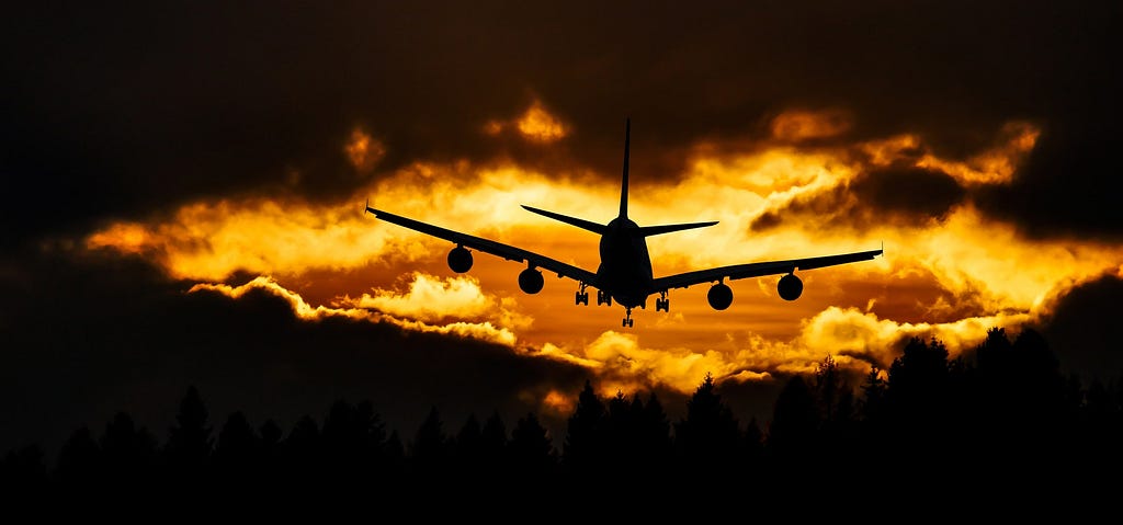 Airplane silhouette in the sun with clouds.