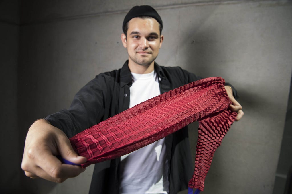 Aeronautical engineer Ryan Mario Yasin, the founder of children’s clothes company Petit Pli, holding out a pair of pants with patented Petit Pli folding.