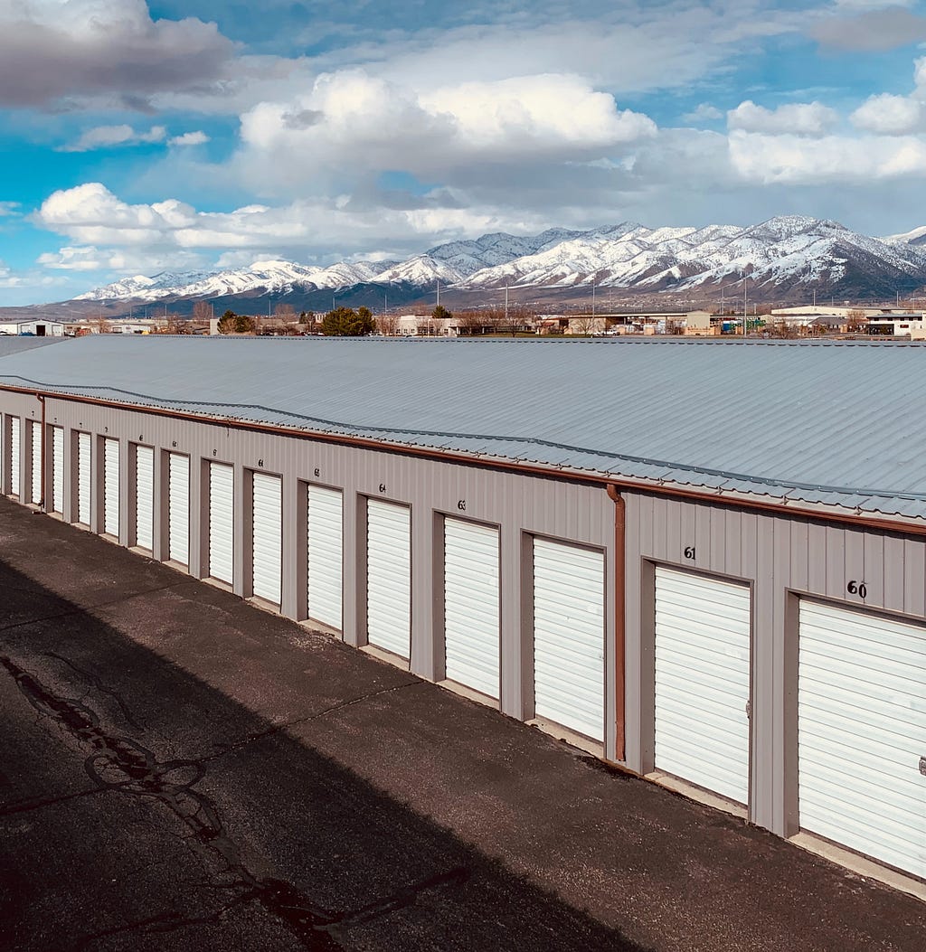 Bird’s eye view shot of storage unit with mountains and clouds off in the background.