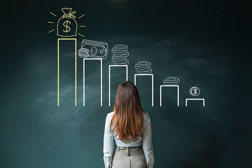 Business woman standing in front of a blackboard with a financial chart.