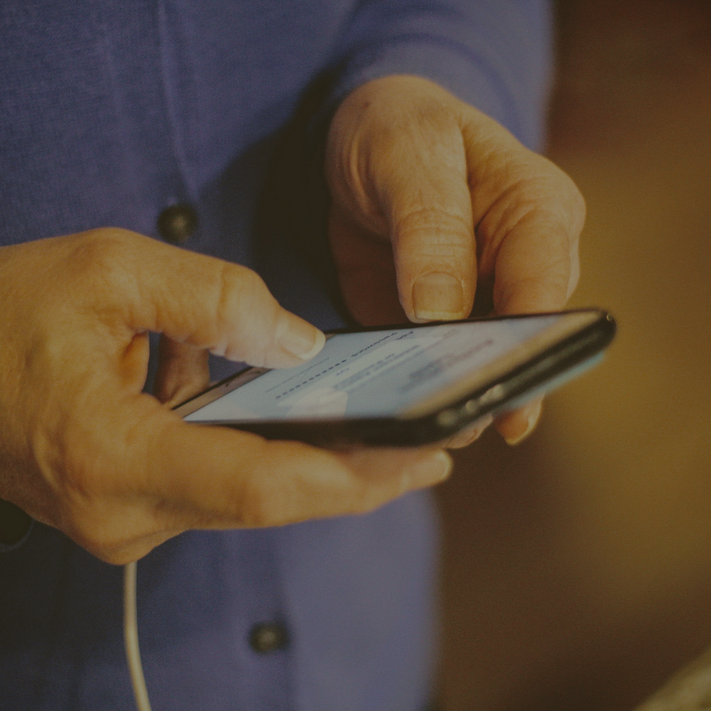 Someone textign on a phone, close up of just the hands and phone.