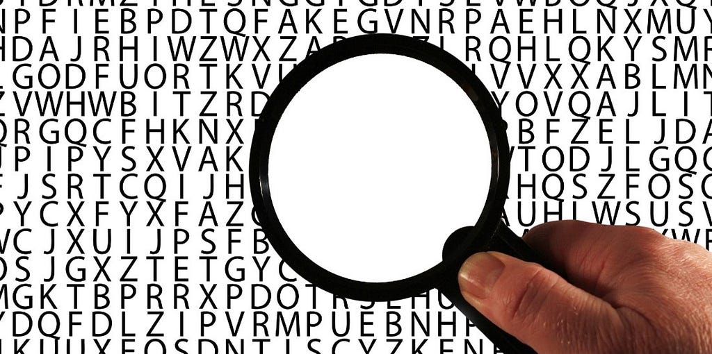 Magnifying glass over lines of randomized capital letters