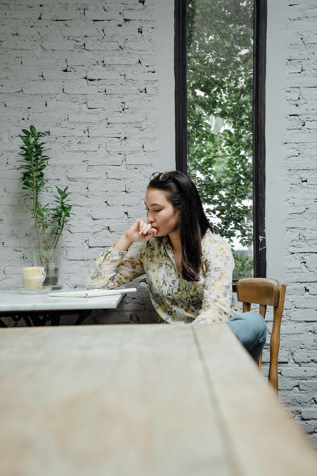 Young asian woman thinking at a cafe
