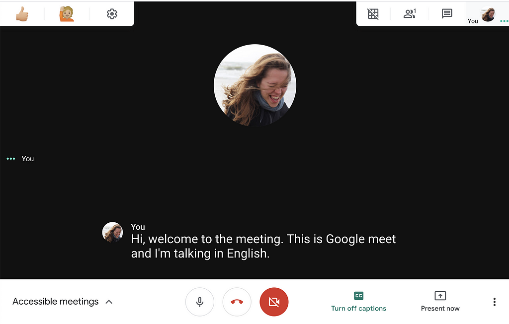 Example of captions in english in google meet bottom center with extensions: nod-reactions (top left) & grid view (top right)