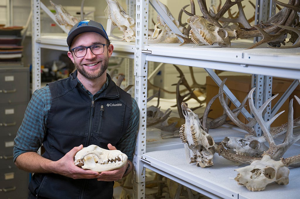 A picture of Connor Meyer holding a wolf skull.