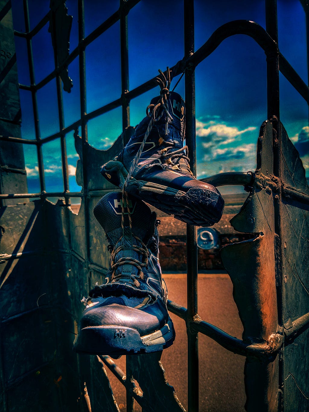 A pair of walking boots dangling from a monument