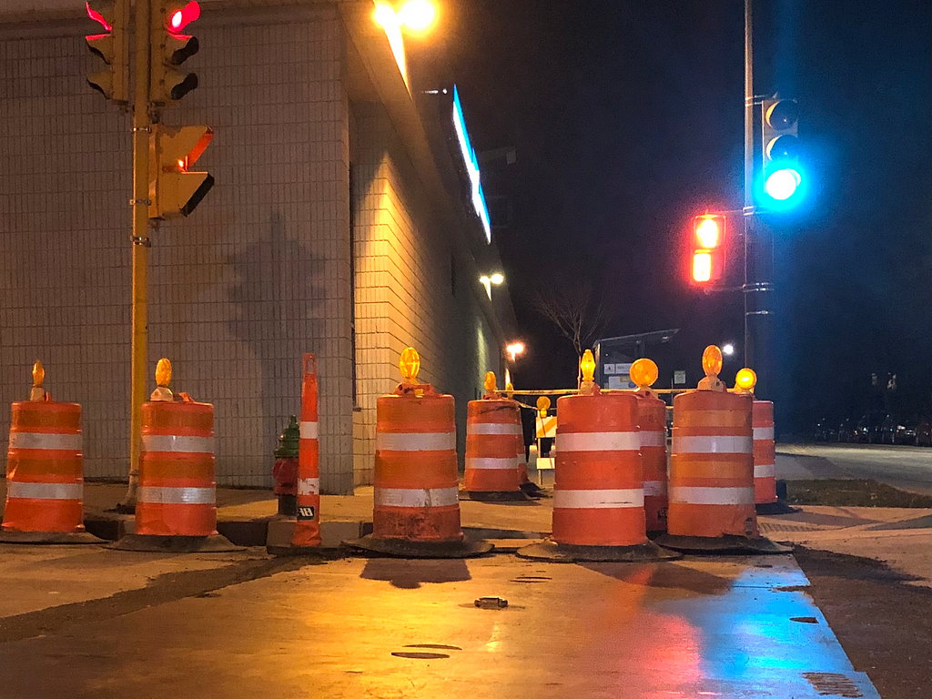 Traffic barrels and uneven surfaces encompass this Milwaukee intersection, forcing pedestrian traffic into dangerous spaces.