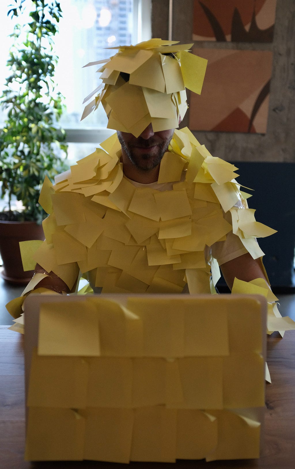 A man and his laptop covered by Post-it notes