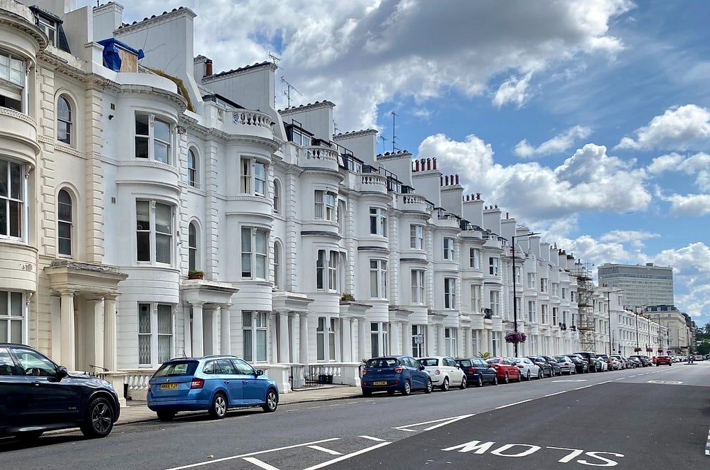 A long row of identical white houses going down the street into the distance