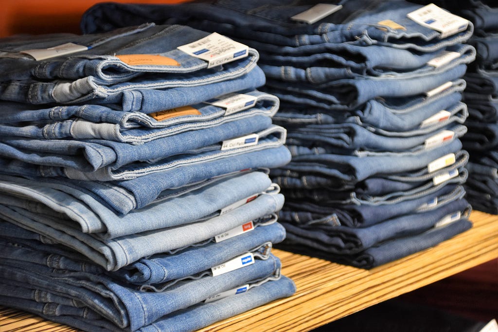 Stacks of blue jeans on a shop shelf