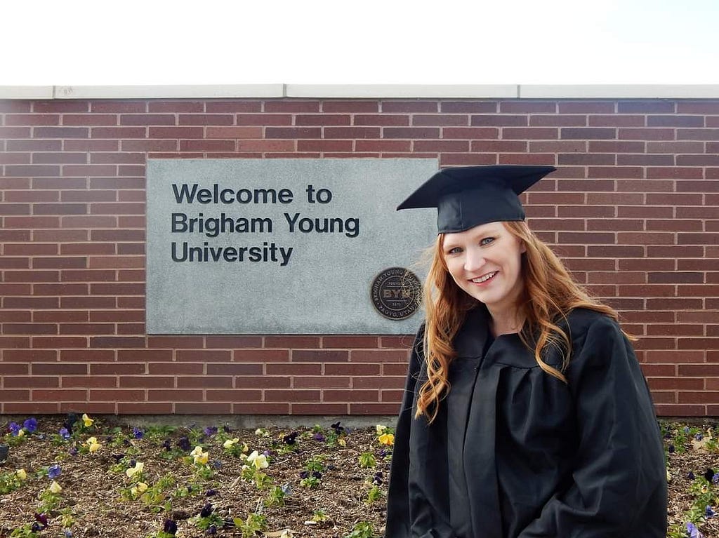 Veronika in a cap and gown in front of text reading, “Welcome to Brigham Young University.”