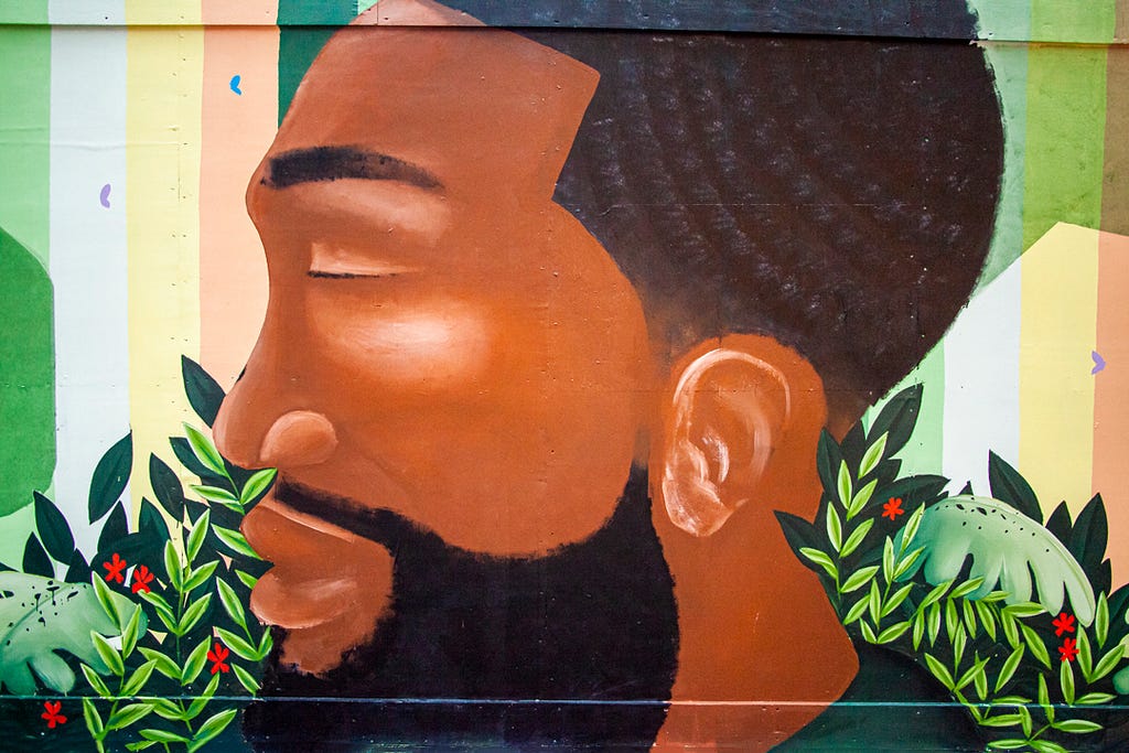 A painted future representation of Michael Brown with tropical leaves around him.