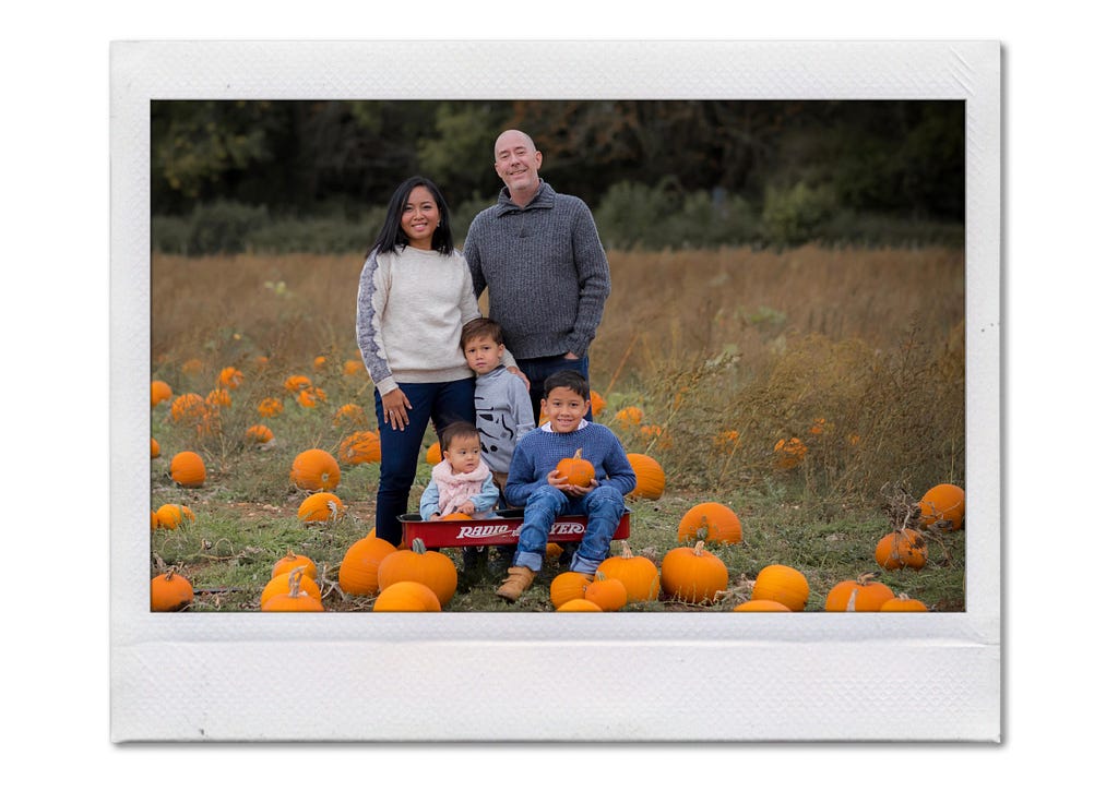 A portrait of mixed race family in a pumpkin field in South of England