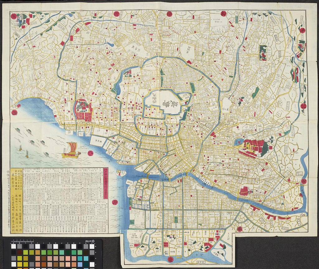 A large coloured wood cut print of a map of Edo, in Japanese. The map represents the whole city area, with roads highlighted in yellow, and major temple and shrine areas within the city and in its outskirts represented pictorially.