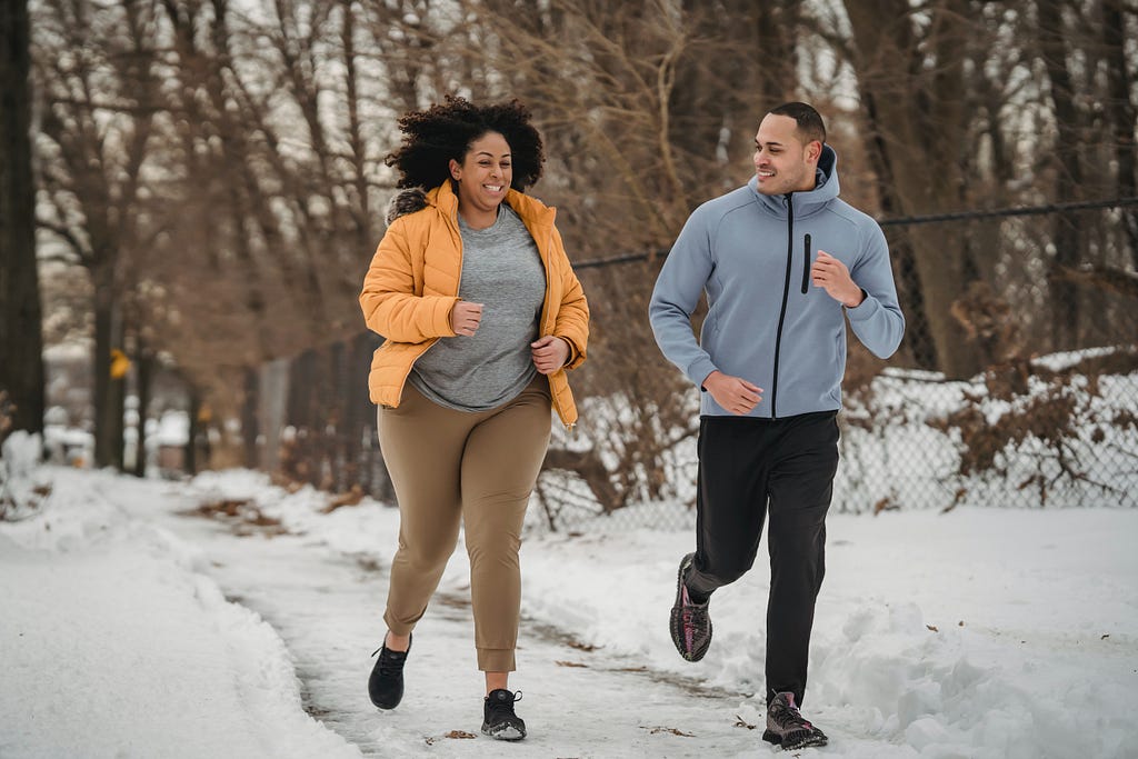 Man and woman running outside on a snowy day