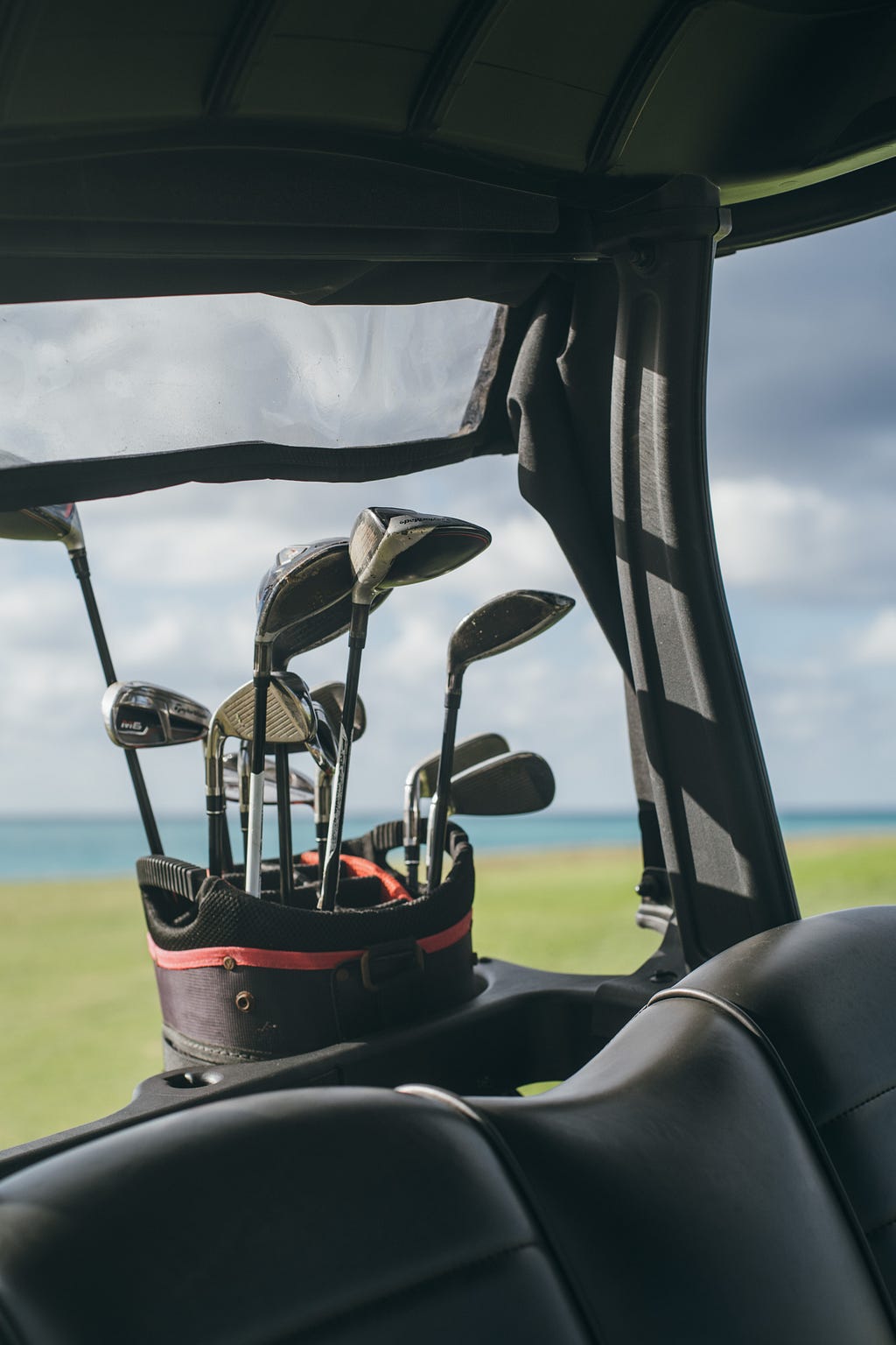 A set of golf clubs with a Caribbean paradise in the background.