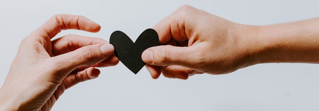 Photo by Unsplash of a heart held by two people