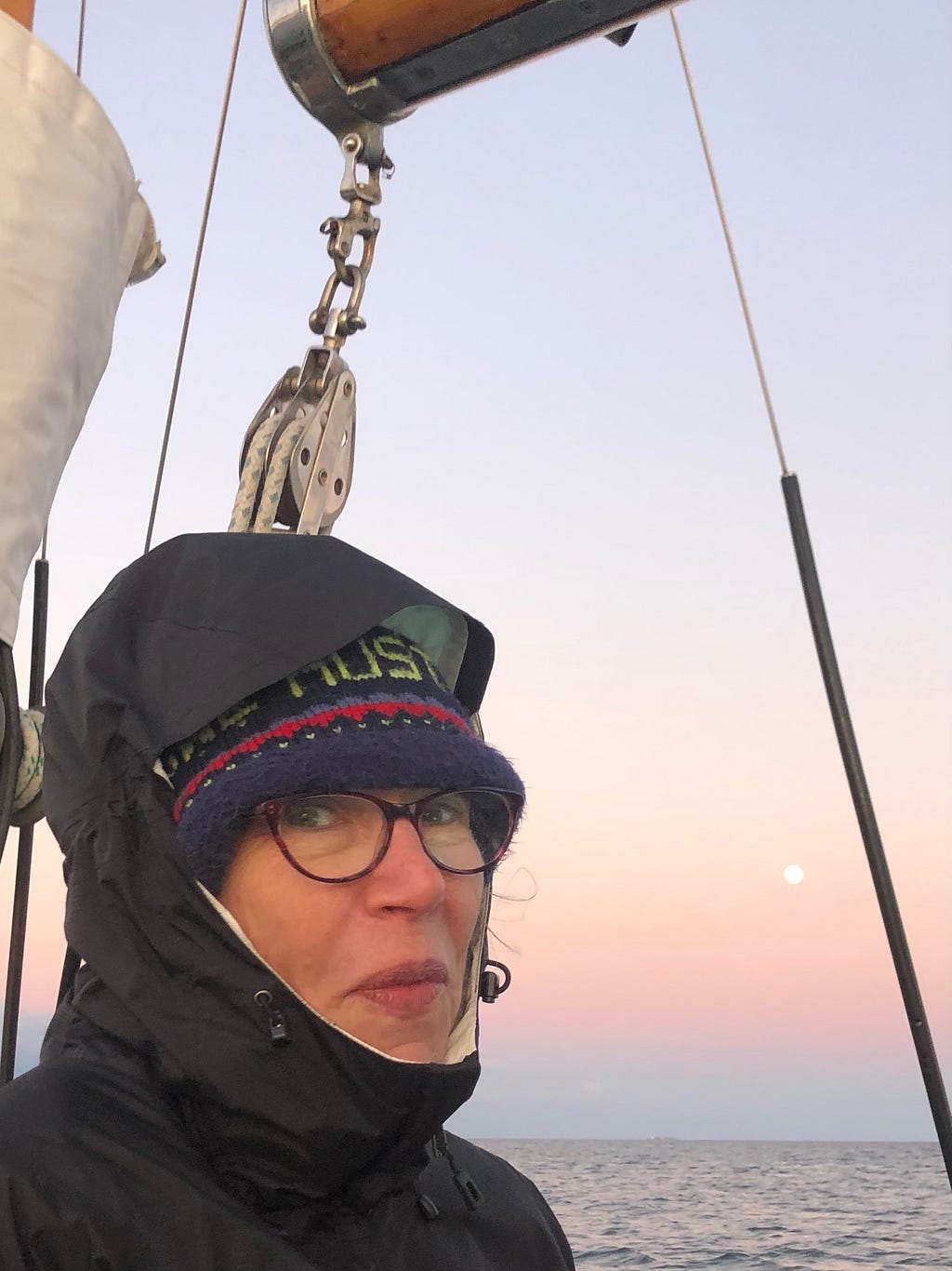 The author takes a selfie capturing the moon off the side of the boat.