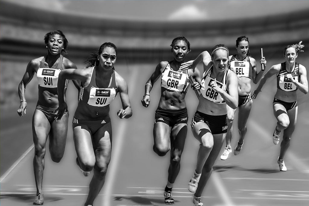 Black and white picture of six female runners racing and wearing sport bibs.