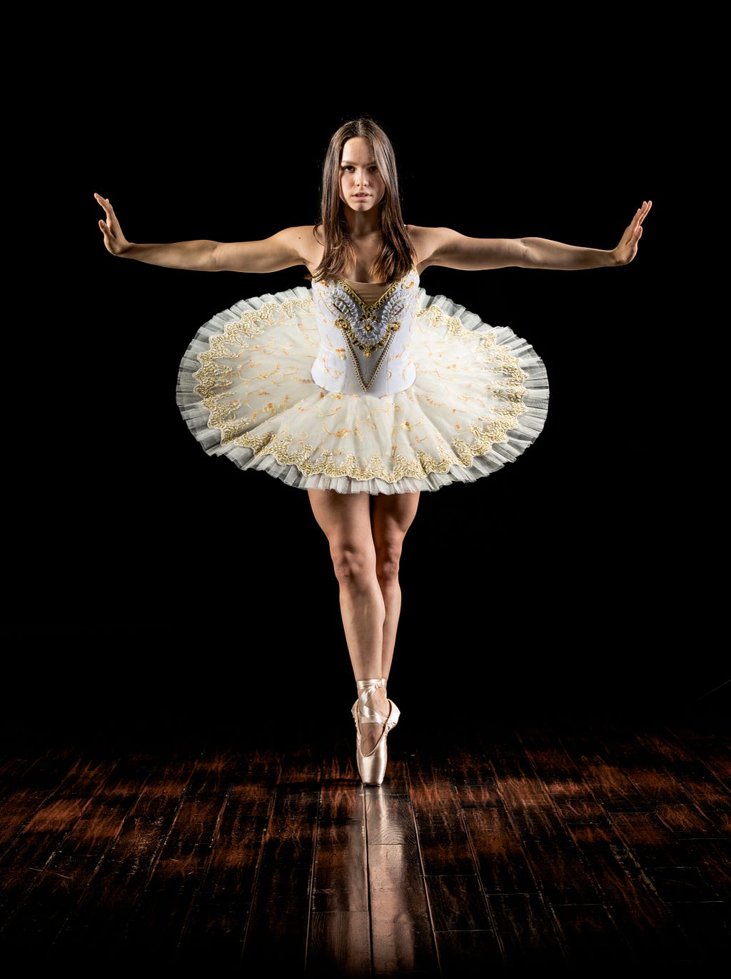 Photo by David Hofmann on Unsplash — Ballerina poses on her toes and with her arms out