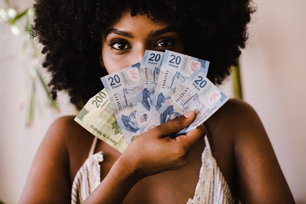 Woman holding money over her face
