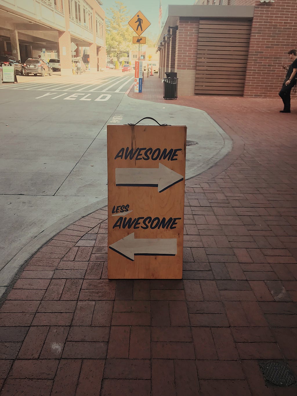 A sign with two arrows pointing in opposite directions. One arrow says Awesome, the other arrow says Less awesome.