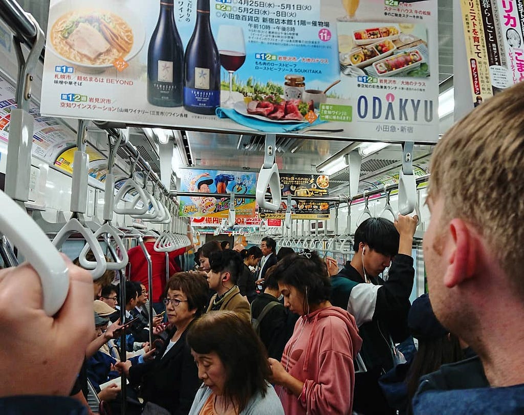 The back of my husband’s head as he looks into a packed Tokyo subway train