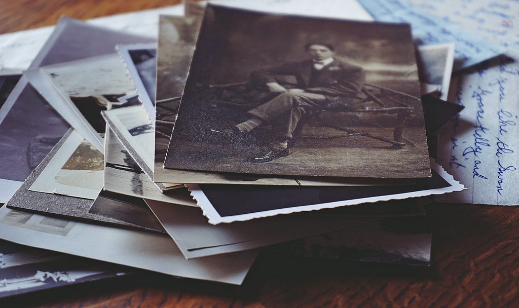 Old photographs of a person on a desk.