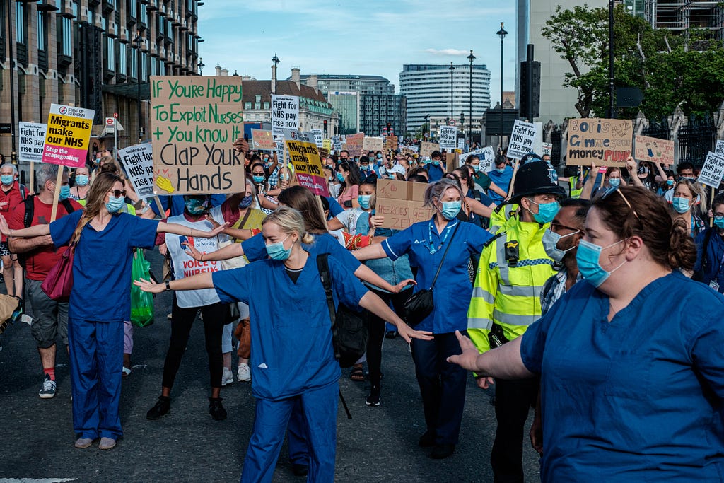 Protestors in the UK wearing hospital scrubs