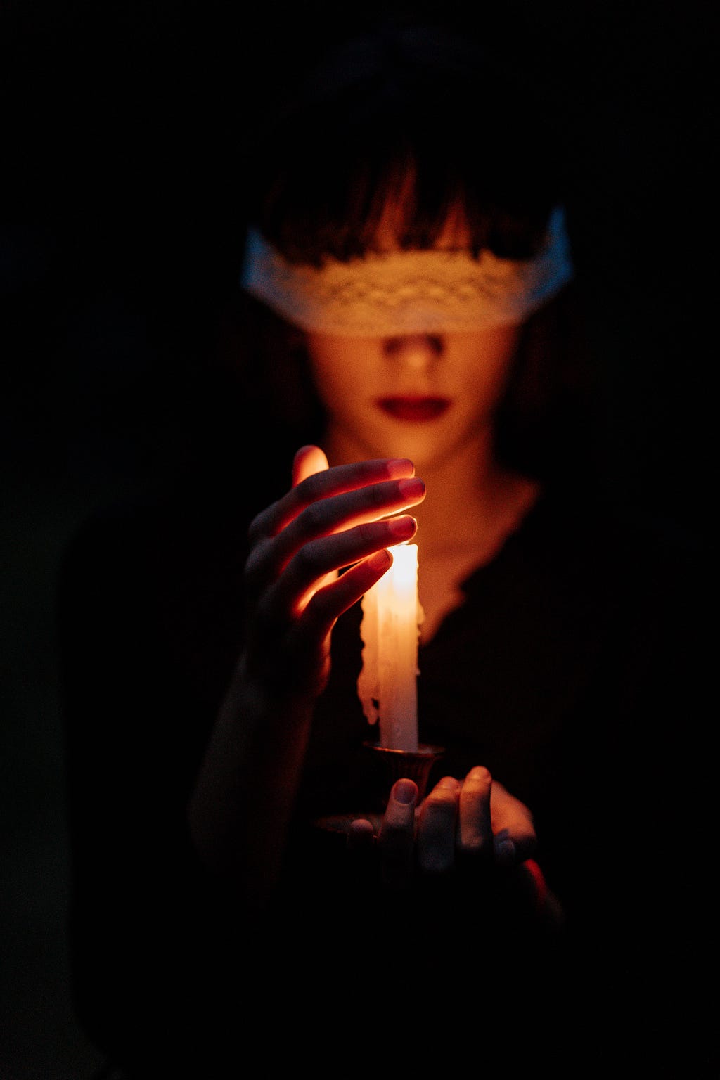 a blindfolded woman with candle