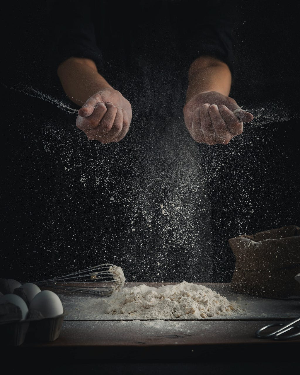 A person sprinkling flour