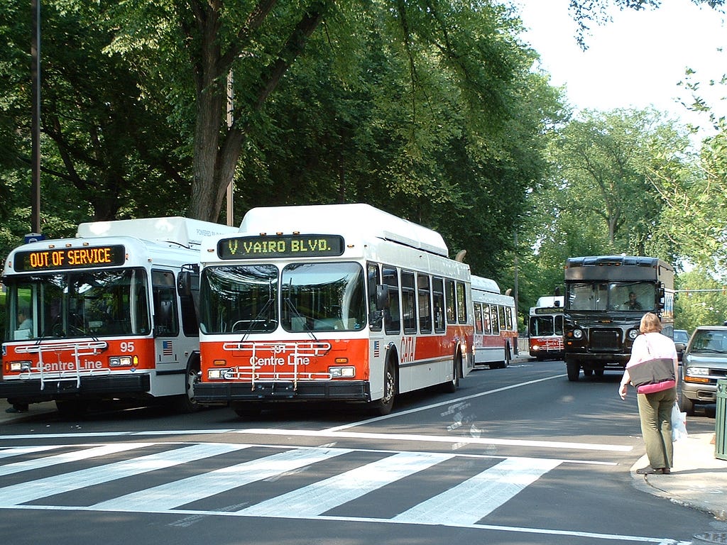 Two buses stopped at a cross walk