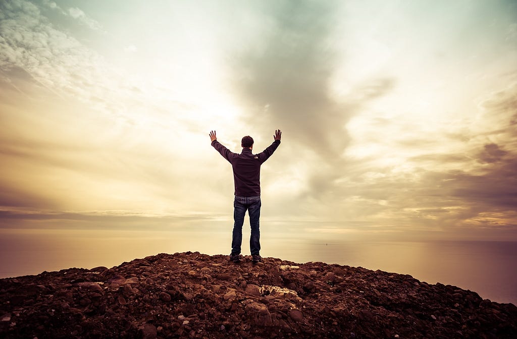 Man standing with upraised hands in worship