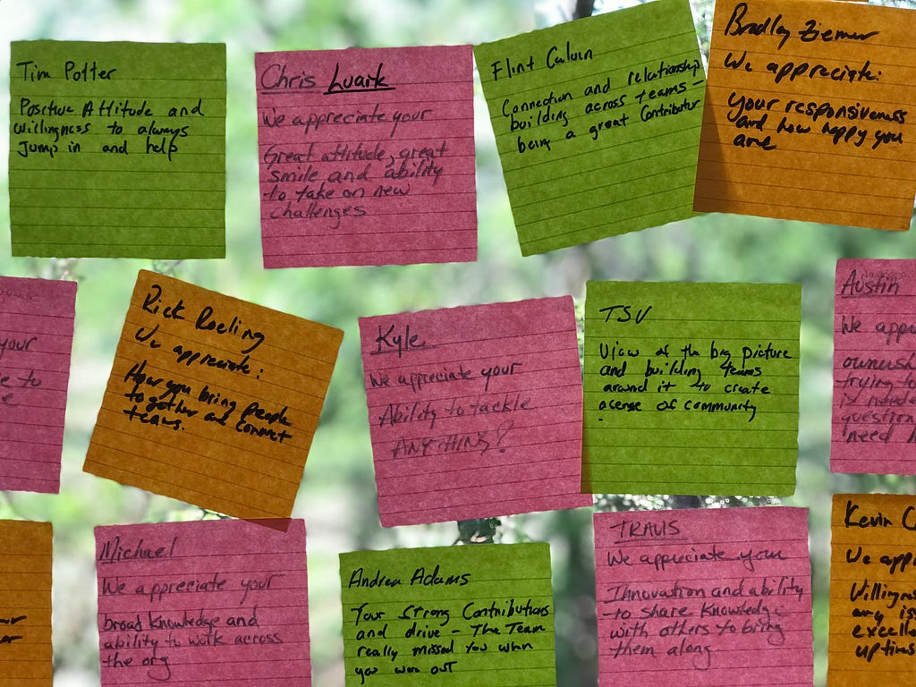 Colorful sticky notes on a window filled with words of affirmation.