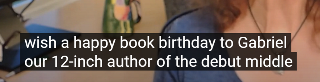 Close-up screencap of YouTube’s auto-captions that say, “wish a happy book birthday to Gabriel our 12-inch author…”