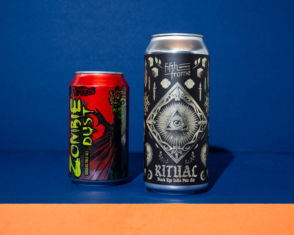 Two beer cans side-by-side. One from Three Floyds Brewing that uses zombiue imagery and the other form Fifth Frame Brewing that uses occult iconography tio craete a dark mode for their beer called Ritual.