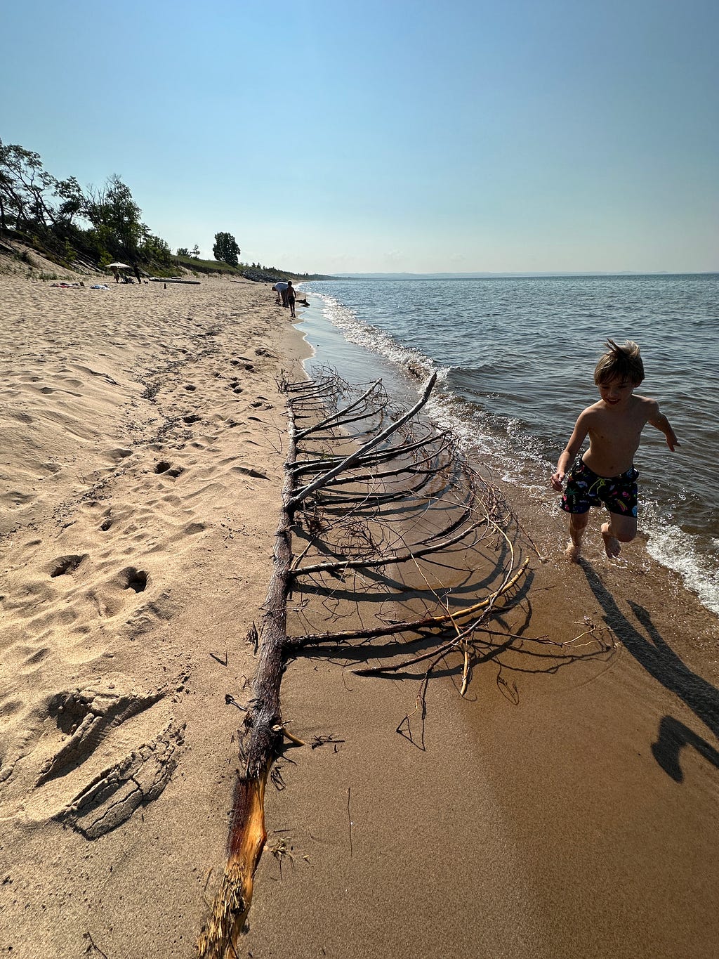 Boy running along the beach of Lake Superior