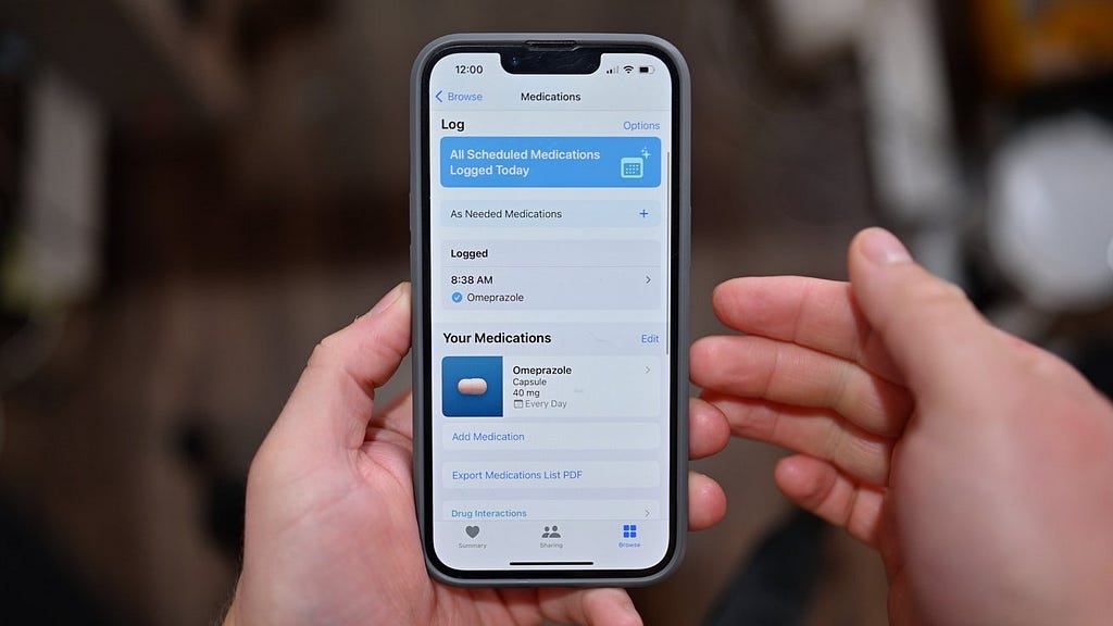 Person holding phone showing the medication tracker home screen with as needed medications