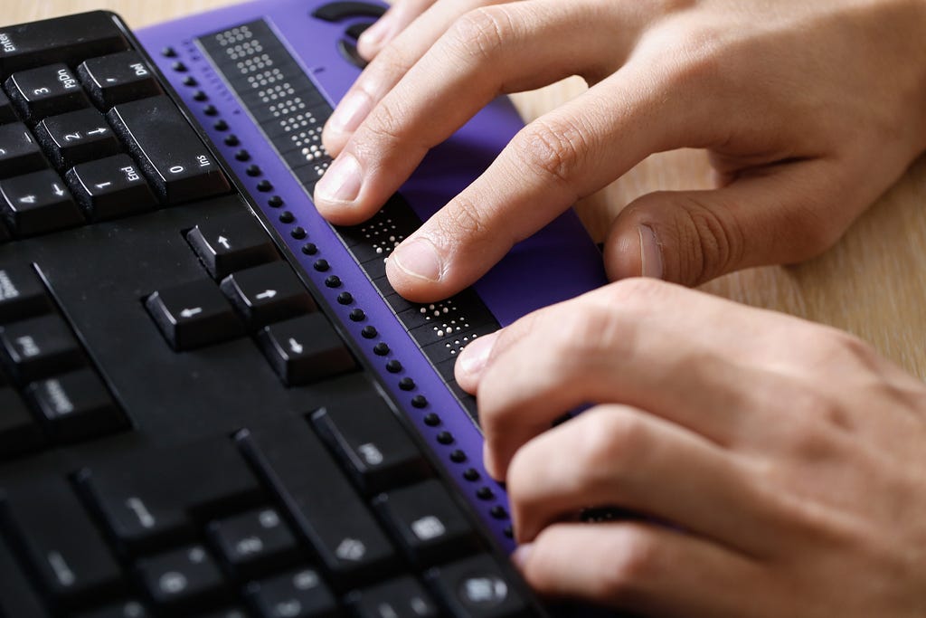 Pessoa cega usando o computador com display Braille